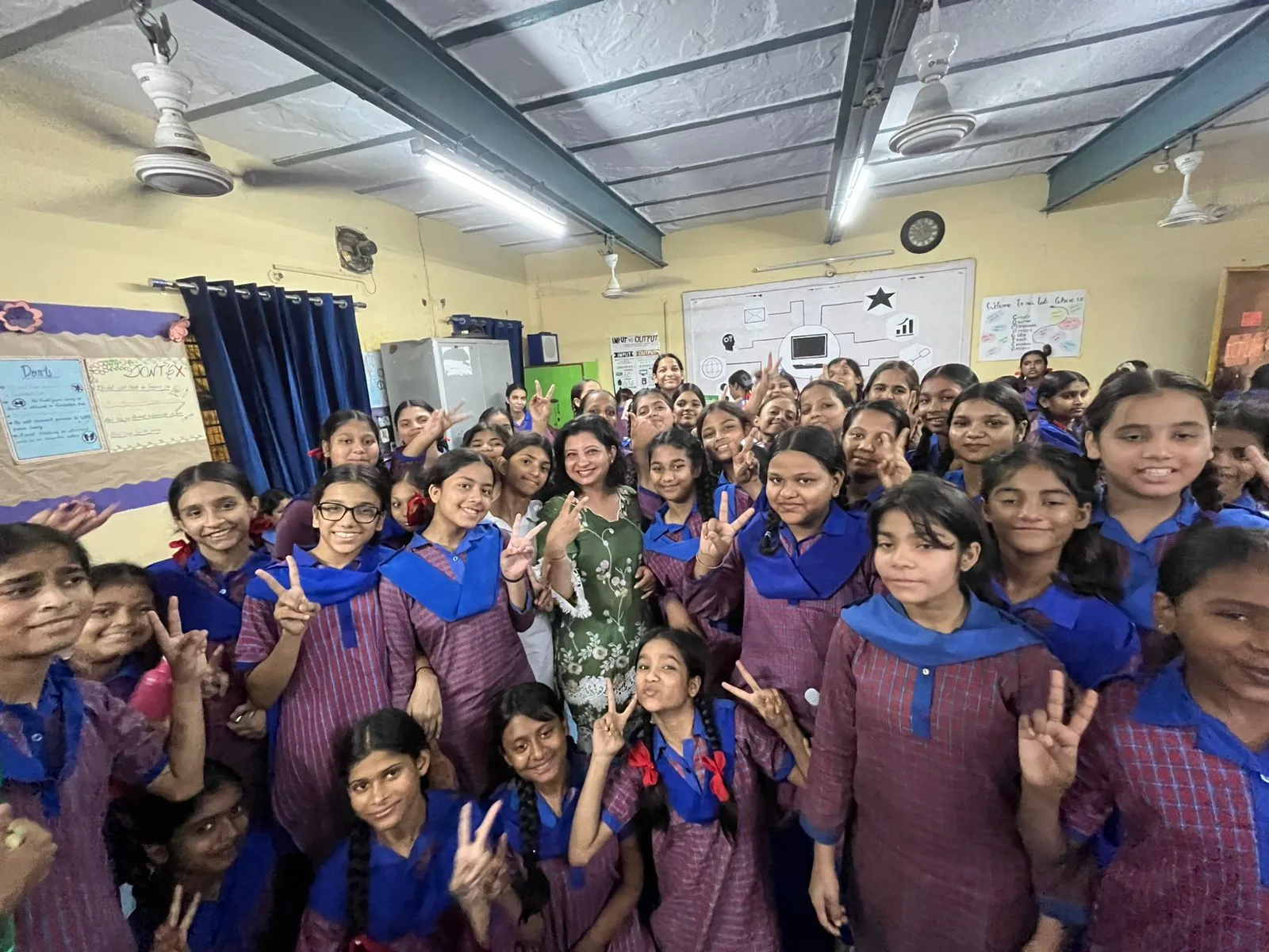 A facilitator standing with a large group of school students in a classroom